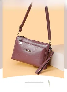 Close-up of multi-layer mauve leather crossbody bag with metallic zipper and textures