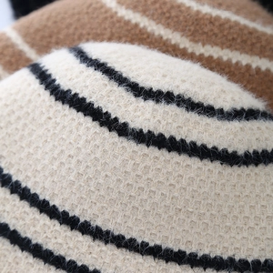 Close-up of color-block knit bucket hat showing soft wool texture and striped patterns