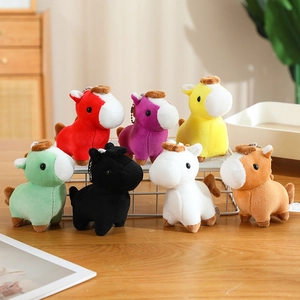 Group of colorful plush pony keychains in various shades on a wooden tabletop
