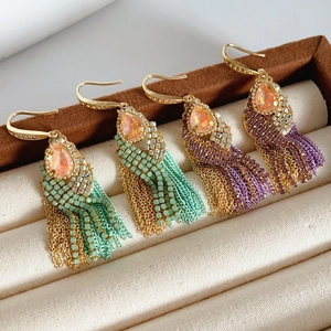 Detailed view of bohemian tassel earrings with zircon studs and green purple beads