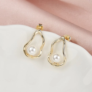 Macro view of gold irregular geometric pearl earrings with S925 silver stud stamp