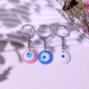 Detailed view of pink blue and white evil eye keychains with silver metal ring