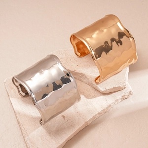 Minimalist wide textured metal cuff bracelets in gold and silver finish on stone base
