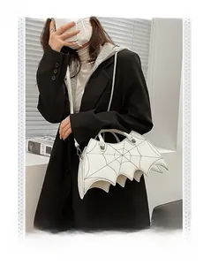Detail of white gothic bat bag showing spider web stitching and metallic studs