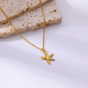 Golden starfish pendant necklace with fine texture on a natural stone background