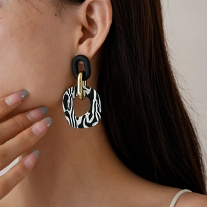 Modern acrylic geometric earrings with zebra stripes and gold metal ring on model