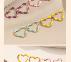 Macro detail of heart-shaped earrings in pastel macaron colors with golden metal frames