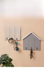 Detailed view of Nordic house-shaped wooden key rack with metal hooks and HOME letters