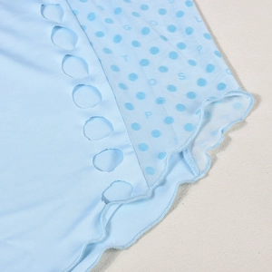 Detail of light blue knit dress with polka dot mesh, hollow out design and wavy hemline