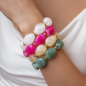 Detail of four-piece resin bracelets with oversized marble-textured oval beads and gold spacers