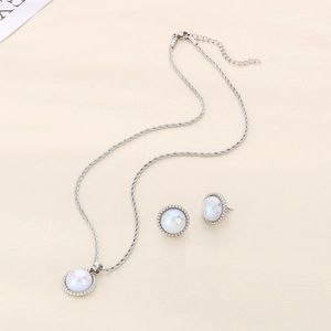 Macro detail of silver necklace and earrings set with white opal gemstones and bead borders