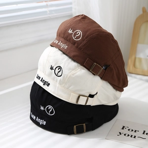 Dettaglio di cappelli docker marroni, bianchi e neri con ricamo circolare M-?