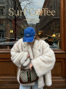 Look urbain avec un manteau en fausse fourrure blanche et une casquette bleue brodée