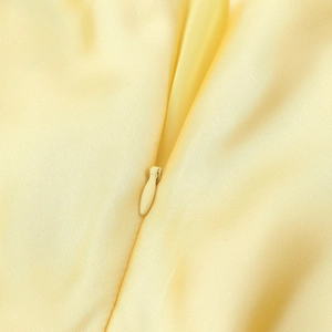 Vue détaillée d'une fermeture éclair invisible sur une robe jaune clair en ramie