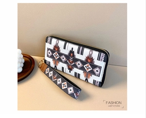 Detail of tribal geometric pattern on long zipper wallet with gold hardware and wristlet
