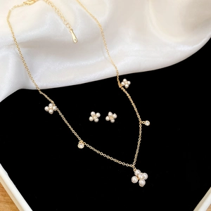 Detailed view of gold plated four-leaf clover jewelry set with pearls and zircons
