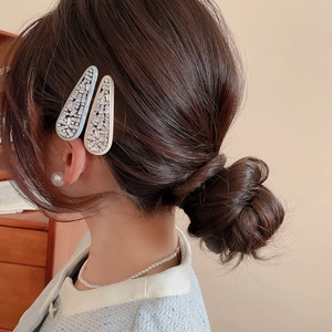 Detailed view of light blue and cream zircon arrow hair clips on a model's hair