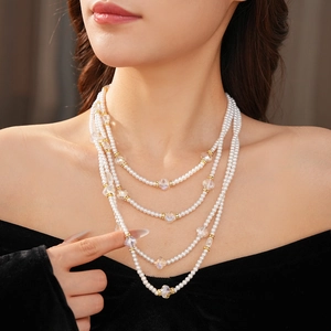 Élégant collier de perles et cristaux à quatre rangs porté par un mannequin