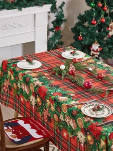 Detail of red plaid Christmas tablecloth with holly, ornaments and ginger bread patterns