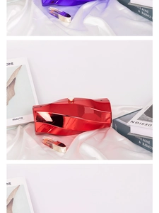 Macro detail of glossy metallic mirror finish clutch bags in red and purple colors