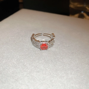 Detailed macro view of an open ring featuring a square orange zircon and silver finish