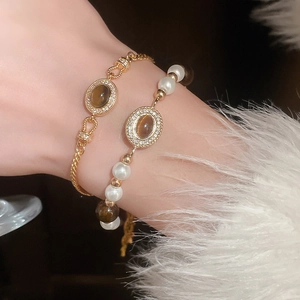 Détail d'un ensemble de bracelets perles rétro avec pierre œil de tigre au poignet