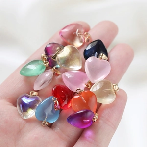 Close-up of assorted jelly acrylic heart pendants with golden rings in a hand