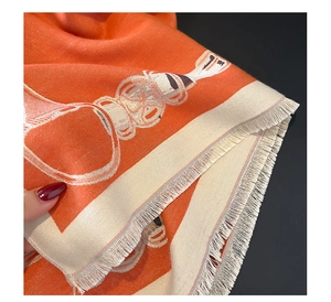 Close-up of orange horse print scarf showing soft fabric texture and fringe details