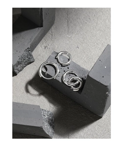 Macro detail of polished S925 sterling silver geometric hoop earrings set on stone