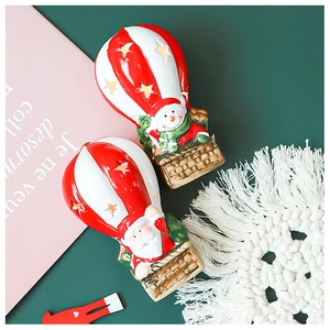 Detail of lit Christmas Santa and snowman hot air balloons with golden stars decor