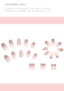 Macro detail of pink ombre press-on nails with 3D butterfly charms and glitter finish