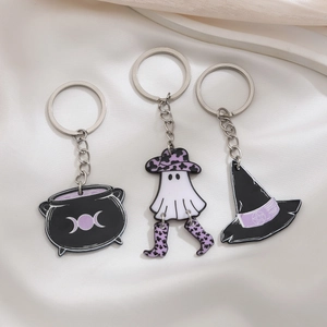 Detail view of Halloween enamel charms featuring ghost in witch hat and black cauldron