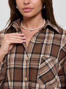 Women's loose plaid shirt in brown with classic lapel and long sleeves on a model