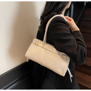 Side view of white PU leather shoulder bag featuring gold hardware and stitching detail