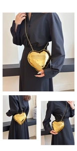 Golden heart-shaped crossbody bag with metallic mirror finish and fine chain strap details