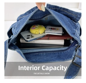 Detail view showing internal capacity and compartments of the denim crossbody bag