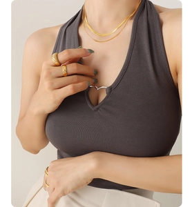 Close-up of a layered golden snake bone necklace with heart cutout detail on top