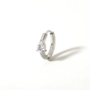 Detailed shot of silver huggie hoop earring with pear-shaped cubic zirconia stone