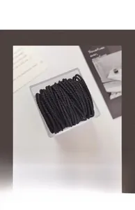 Macro shot of high-elastic black hair ties in a clear acrylic storage box