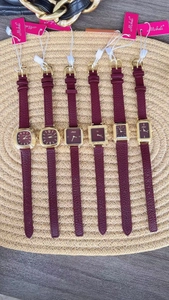 Macro detail of various gold vintage ladies watches with deep red leather straps