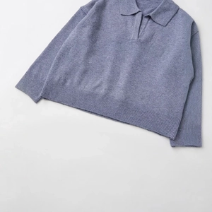 Flat lay of a mist blue cashmere blend polo knit sweater with V-neck and ribbed cuffs