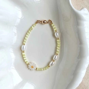 Detail of beaded bracelet with glacier blue cat eye stones, baroque pearls and daisy charms