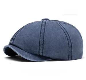 Detailed top view of a washed blue cotton newsboy cap with button top and stitching