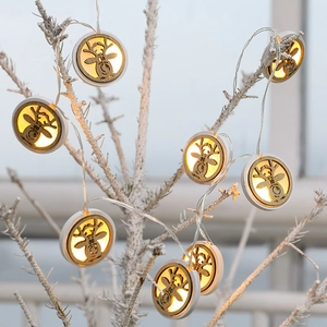 Nordic wooden LED reindeer head string lights with warm white glow on snowy branches