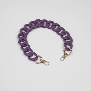 Close-up of matte purple acrylic bag chain with gold spring rings and lobster clasps