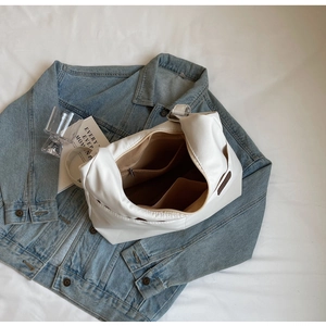 Detailed interior of a white tote bag featuring a zipper pocket and brown fabric lining