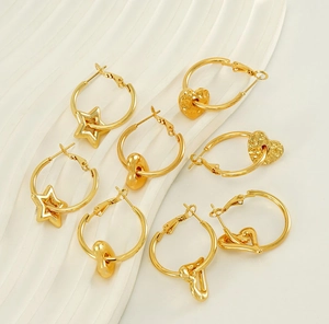 Detail of 18K gold plated hoop earrings set featuring star and heart shaped charms