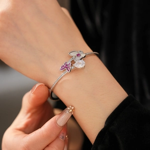 Detail of silver bangle with pink zircon butterfly, water drop stone, and flower motifs