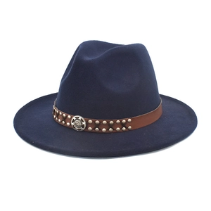 Navy blue wool fedora hat with brown leather rivet band and vintage metal emblem