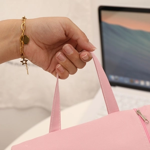 Detailed close-up of a pink canvas file bag handle with a star charm bracelet